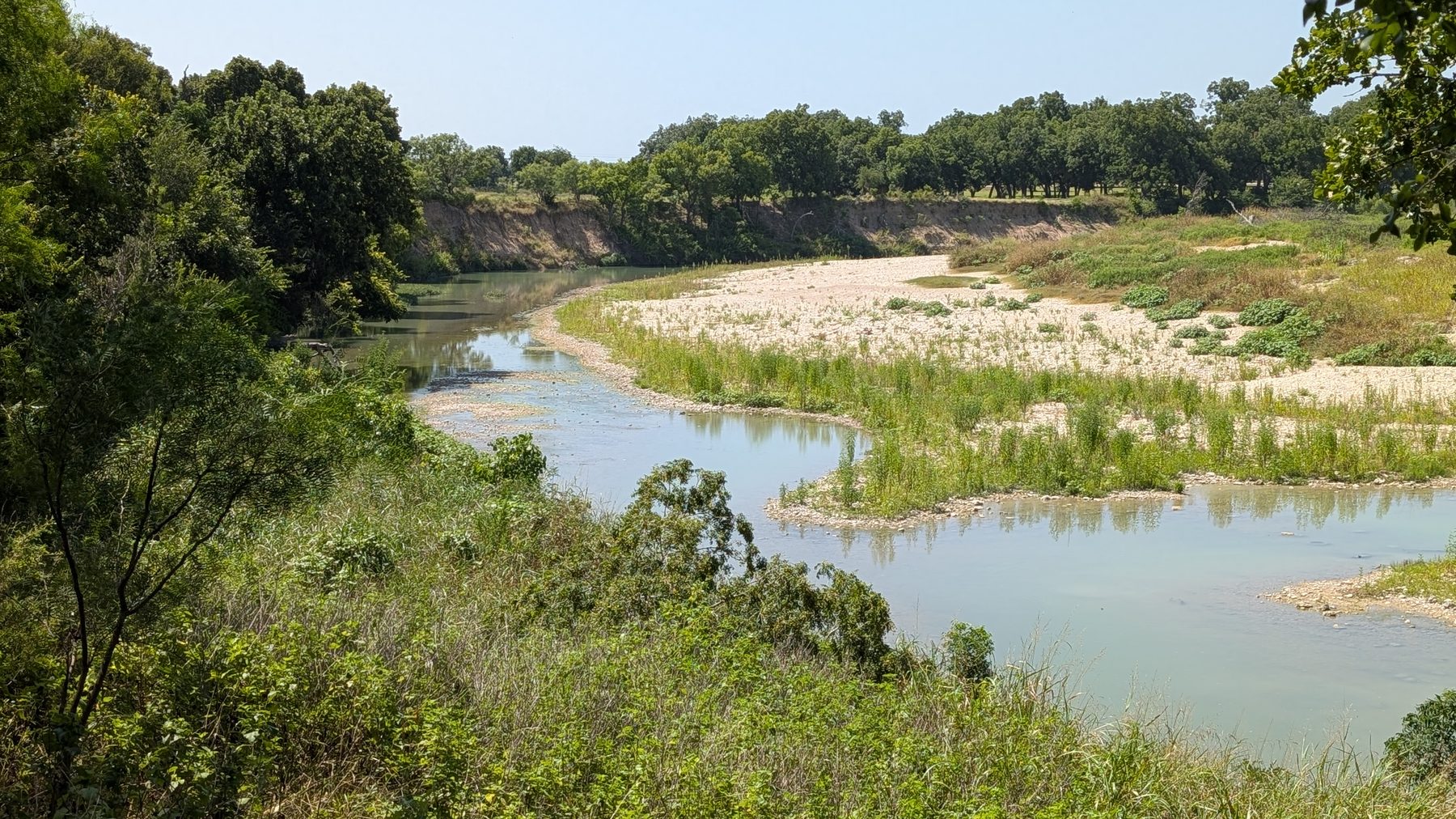 The Lampasas River below the tract — a wide bend with a gravel bar, seen from the wooded bank